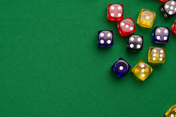 several multi-colored cubes lie on a green table