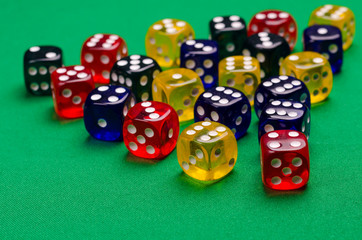 several multi-colored cubes lie on a green table