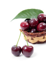 Yellow wooden basket with red sweet cherry isolated on a white background..