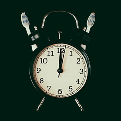 Dental hygiene time concept. Black alarm clock with black background.