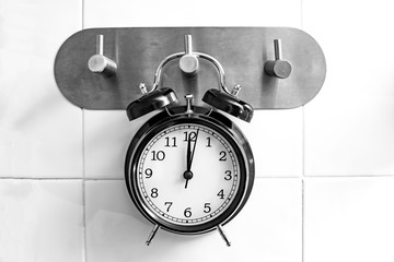 Concept showering time. Black alarm clock