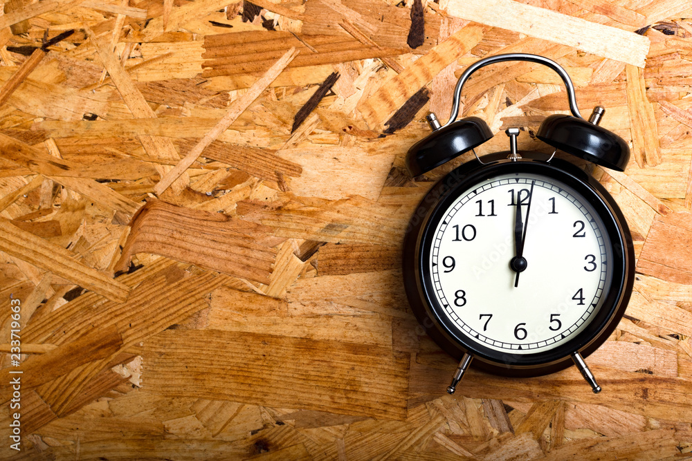 Wall mural black alarm clock in wood type oriented strand board.