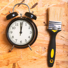 DIY time concept. Tools surrounding a black alarm clock