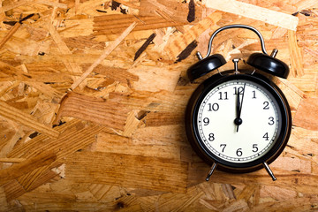 Black alarm clock in wood type Oriented Strand Board.