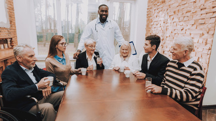 Young and Old People Sit Together. Nursing Home.