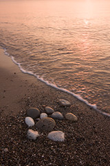 Shore of sea with sand, stones and water during sunrise