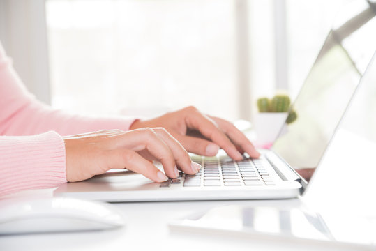 Closeup female hands typing on laptop keyboard. Woman working at home office concept.