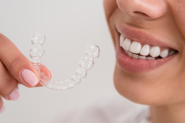 girl with a beautiful smile holding a transparent mouth guard