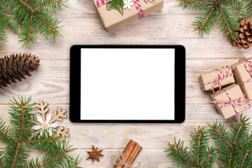 Fototapeta na wymiar Digital tablet mock up with rustic Christmas wood background decorations for app presentation. top view with copy space