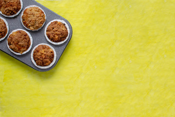 Fresh baked muffins on bright yellow background