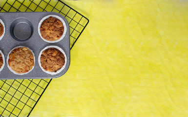 Fresh baked muffins on bright yellow background