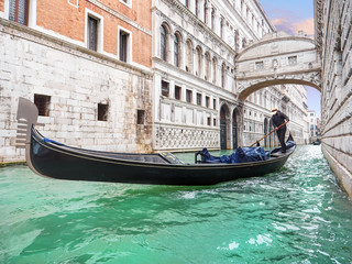 Bridge of sighs. Traditional Venetian transport. Gondola floating along the canal