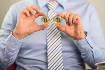monety bitcoin trzymane w dłoniach - obrazy, fototapety, plakaty