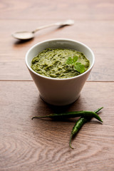 Healthy Indian Green Chutney or Sauce Made using Coriander, Mint And Spices. isolated over moody background. Selective focus