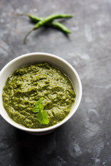 Healthy Indian Green Chutney or Sauce Made using Coriander, Mint And Spices. isolated over moody background. Selective focus