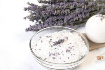 Natural herbal sea salt with aromatic lavender - perfect for relaxation. Cosmetic jars and bottles with salt, lavender flowers, bath bomb