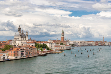 Fototapeta premium View of Venice from the sea. On the right side of the frame you can see the water. On the left side of the frame is the city. Blue sky with various clouds.