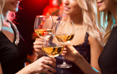 Beautifully dressed girls with glasses of wine at a Christmas party