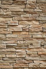 Wall of stone beige surface bricks as a background.