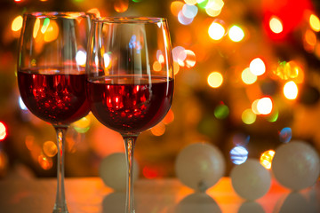 Glasses of wine and Christmas balls on the background of Christmas lights