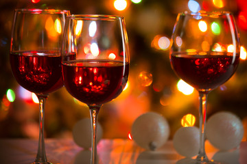 Glasses of wine and Christmas balls on the background of Christmas lights