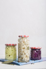 Sauerkraut in jars on a wooden table. Vertical orientation