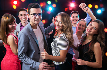 Group of young people having fun dancing at party.