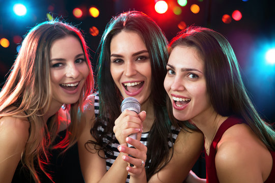 Girls having fun singing at a party