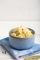 Sauerkraut in a blue bowl on a wooden table