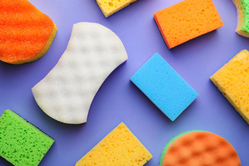 Many different sponges on color background, flat lay