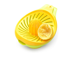 Squeezed lemon and juicer on white background