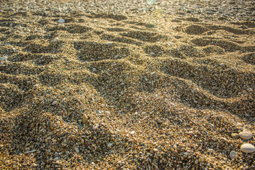 sea shore sand and small stones background texture for wallpaper or banner on tourism and summer vacation holidays theme, copy space