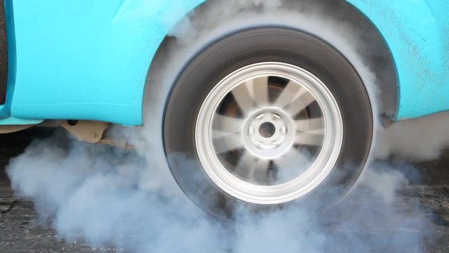 Drag car make tires warm up with smoke, Car racing burnout rubber off its tires in preparation for the race.