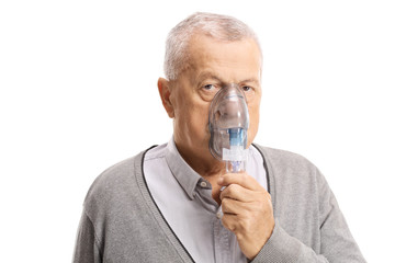 Elderly man inhaling with a mask