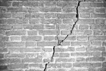 Deep crack in old brick wall - toned image