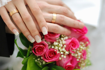 Obraz na płótnie Canvas wedding rings. bridal bouquet of fresh roses on the table. wedding floristry, floristic decorative statement