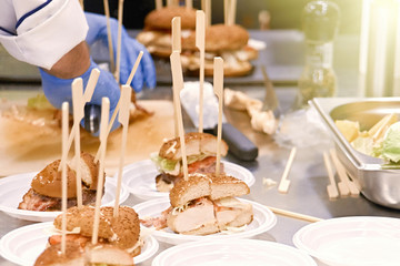The chef prepares many hamburgers on the table in the restaurant.