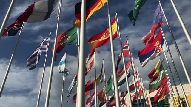 Flags of many countries vawing in the wind with blue sky and white clouds. for political, international trade, relationship concepts