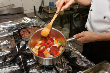 Chef is frying vegatables to make a sauce