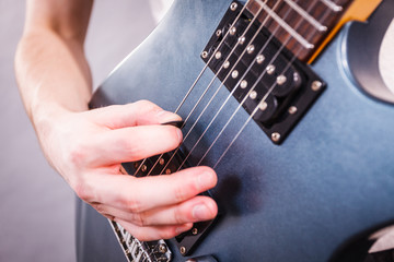 Close up of man playing on electric guitar