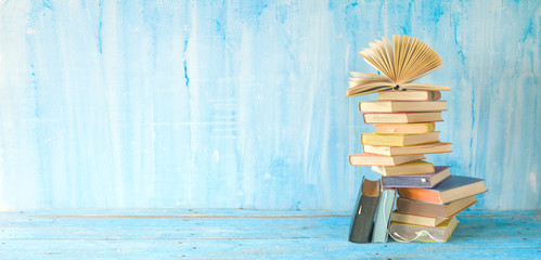 opened book on a stack of books panorama, good copy space. Education, continuing education,reading,...