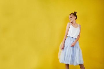 Fototapeta na wymiar young girl on a yellow bright background. beautiful makeup, bright image, place for text