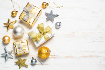 Gold and silver christmas present box and decorations on white.