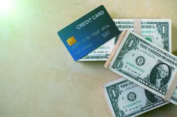 Closeup of blue credit card and dollars on background. Business and finance for pay.