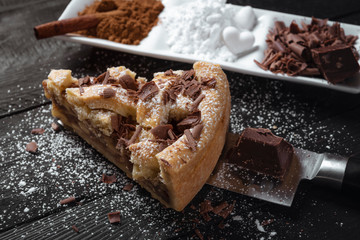 Apple pie piece with chocolate on a knife. Close-up. Home Baking.