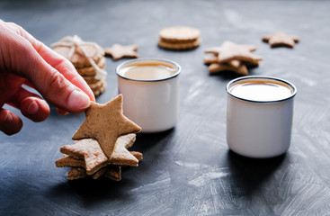 Female hand holding a cookie on tea/coffee party background