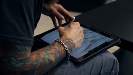 Guy draw picture on tablet computer. Designer works on graphic tablet at PC 