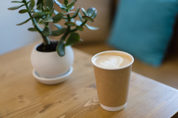 Cup of a latte on a wooden table.