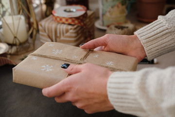 Woman holding Christmas box Gift on black background. Female hands with Presents for winter Holidays. Christmas, New Year, shopping, preparation on Holidays, donation concept