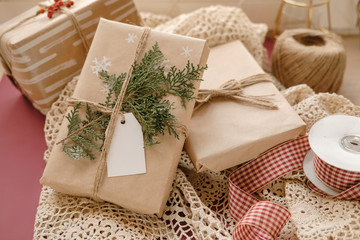 Blank Gift tag on Classy vintage Christmas gift box on lace tablecloth background. Christmas presents with handmade decoration. Close up. Mockup. Copy space.